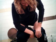 Блонда склонив голову писает в туалете