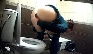 Девушка писает в туалете присев над унитазом