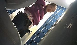 Молодая девица писает в туалете и светит свою пилотку